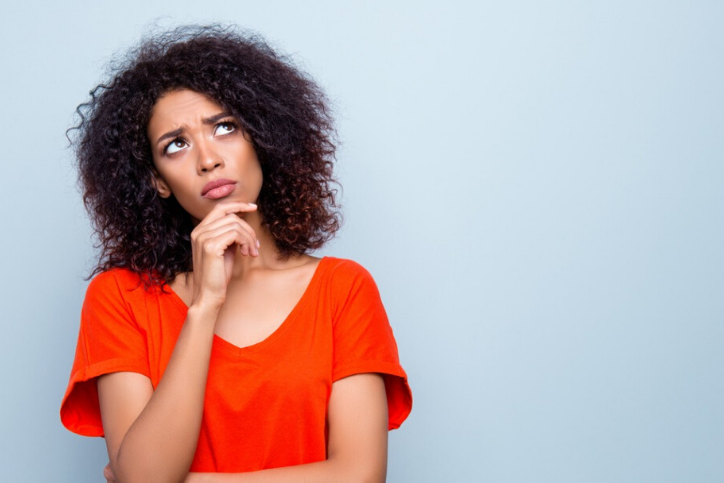 An african american woman looking up at the sky, wondering about Hysteroscopy.