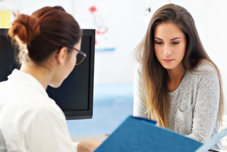 woman talking with gynecologist, taking care of her new year's resolution of finding a GYN.