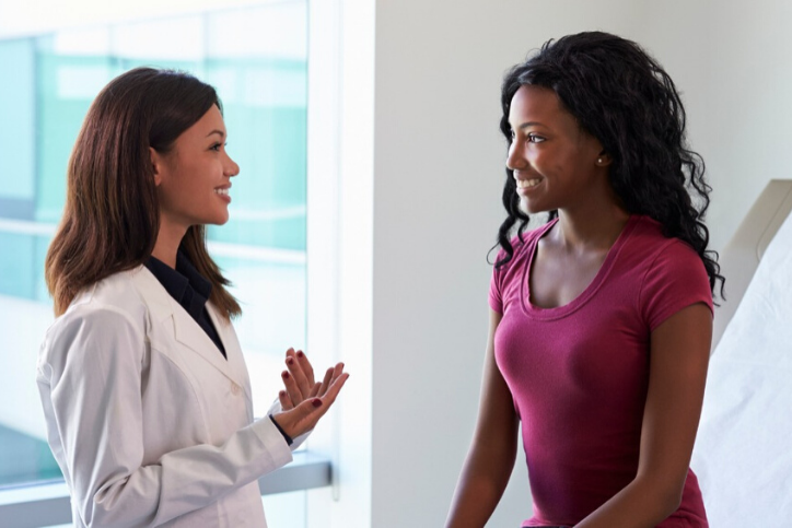 A gynecologist speaking with a patient, discussing understanding the risk of reproductive cancers.