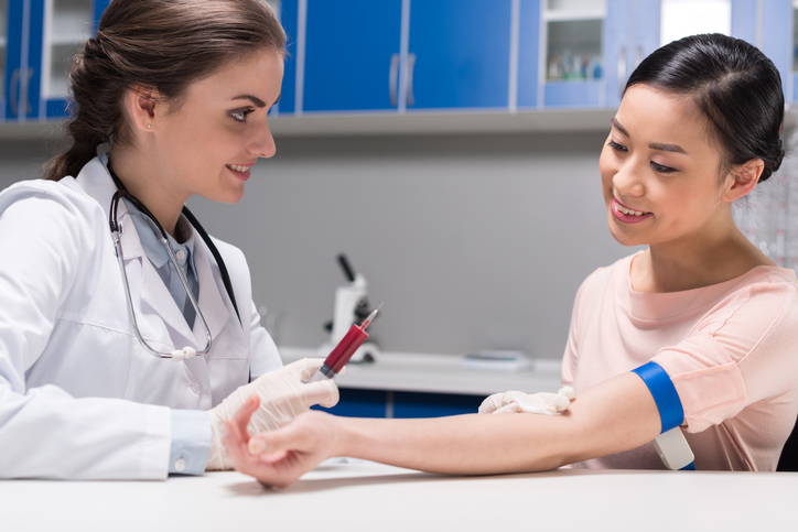 young doctor taking blood sample from patient at laboratory, discussing the Should I Get STD Testing Done?