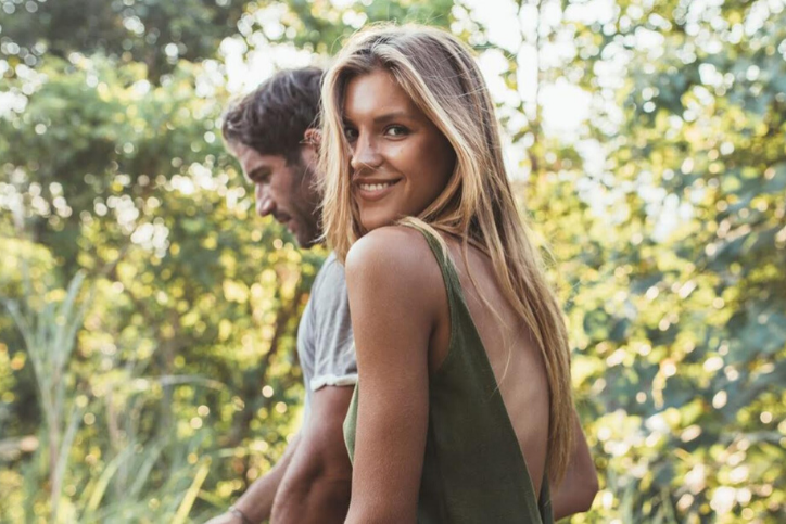 Blond woman walking with her brown haired boyfriend, wondering about health conditions that are related to reproductive health.