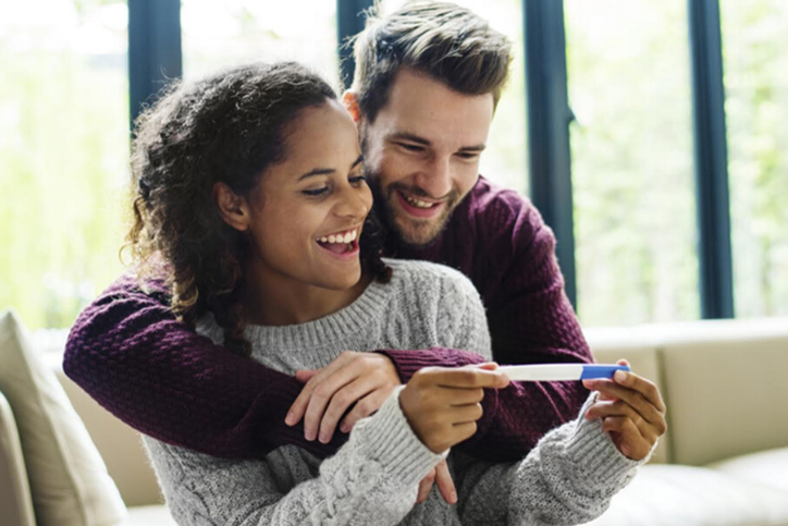 Black woman in an embrace with her white boyfriend, discussing the risks women face when having children.