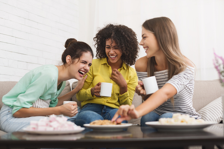 A group of women friends laughing together, discussing common women's health rumors.