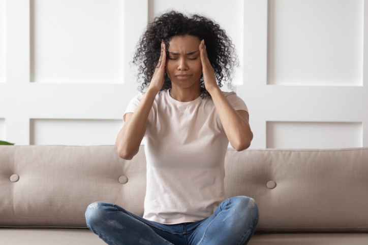 young african american woman with hormonal headache, wondering about women's hormones.