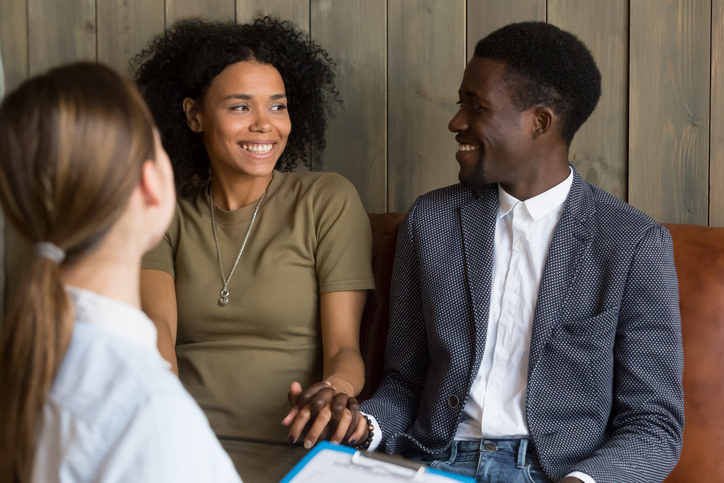 African American couple speaking with a doctor about infertility treatment options.