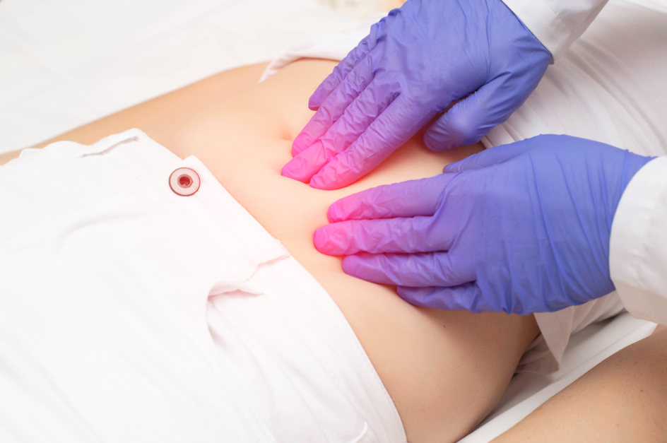A gynecologist doctor probes the lower abdomen of a girl who has pain and inflammation of the reproductive system. Ovarian cyst, endometriosis, pregnancy pathology, discussing a new uterine fibroid treatment called Acessa.