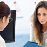 Nervous young lady at gynecology appointment with female doctor.