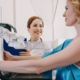 Smiling radiologist standing near patient while making mammography