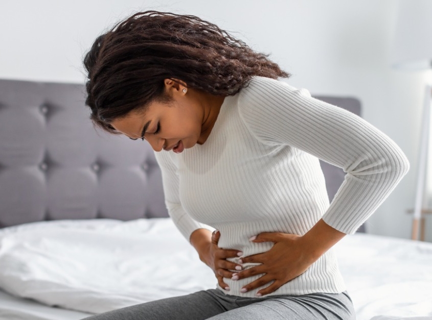 woman suffering from stomachache holding her tummy