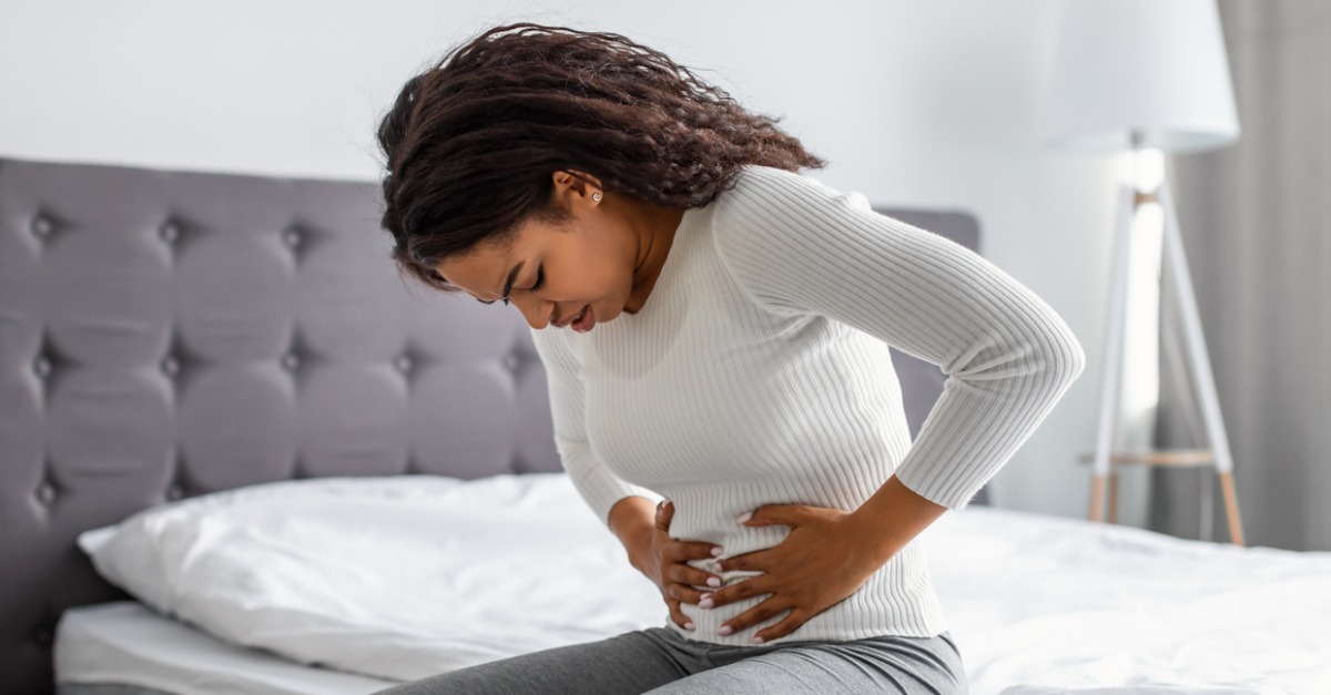 woman suffering from stomachache holding her tummy