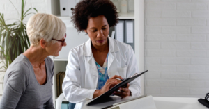 Female doctor showing female patient a clipboard