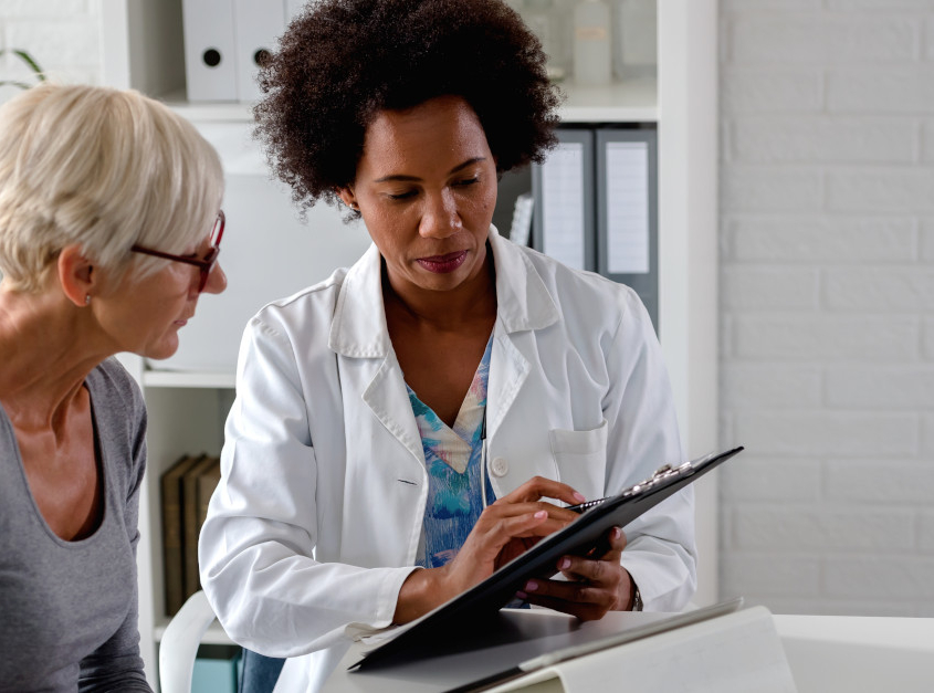 Female doctor showing female patient a clipboard