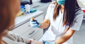 Female lab assistant holding test tube of blood