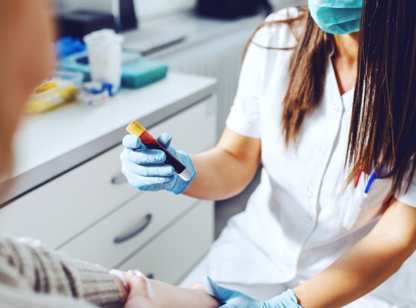 Female lab assistant holding test tube of blood