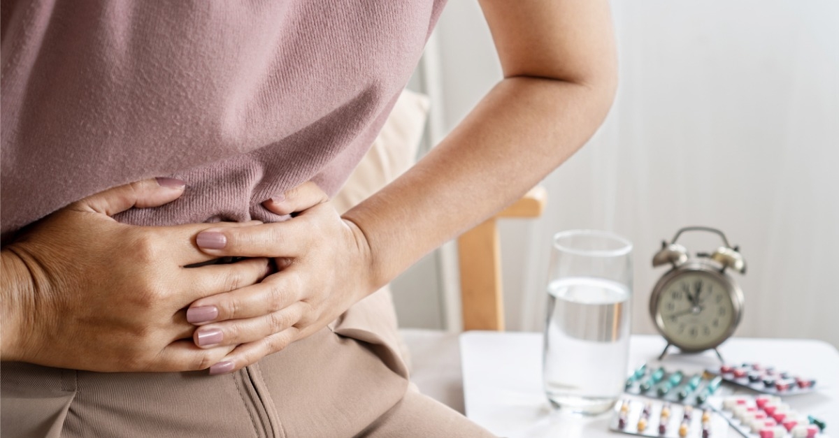 Woman holding lower abdomen in pain