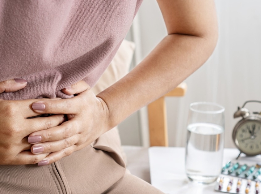 Woman holding lower abdomen in pain