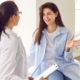 Doctor holding report file with appointment and listening her woman patient in clinic
